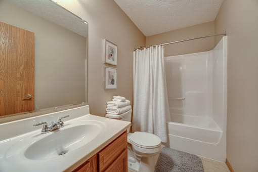 A bathroom with a white sink, toilet, and bathtub.
