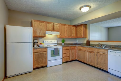 A kitchen with wooden cabinets and white appliances.