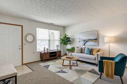A living room with a blue chair and a grey couch.