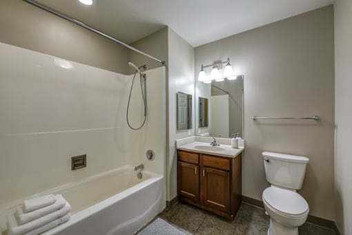 A white bathroom with a tub, toilet, and sink.