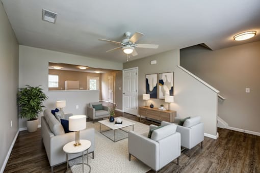 A living room with a grey couch, a coffee table, and a ceiling fan.