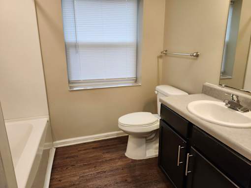 A white toilet sits in a bathroom next to a sink.