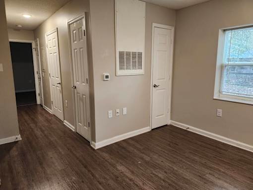 A room with wood flooring and white walls.