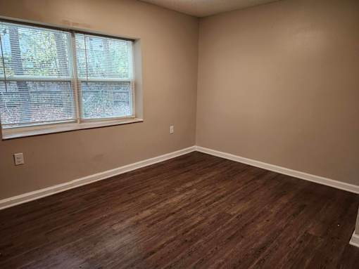 A room with a window and wooden flooring.
