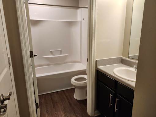A white toilet sits in a small bathroom next to a sink.