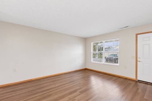 Empty room with wooden floors and a picture on the wall.