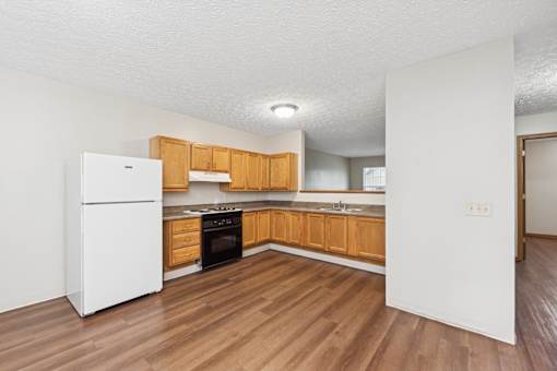A kitchen with wooden cabinets and a white refrigerator.