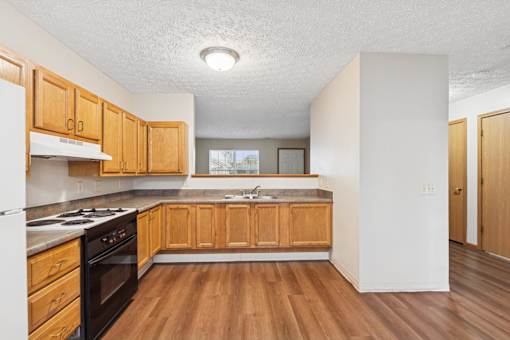 A kitchen with wooden cabinets and a stove top oven.
