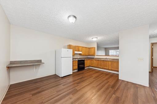 A kitchen with wooden floors and white appliances.