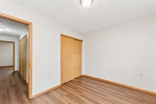 A room with a wooden floor and a brown door.