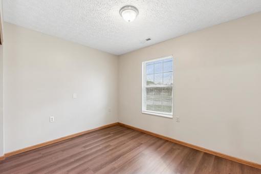 A room with a window and wooden flooring.
