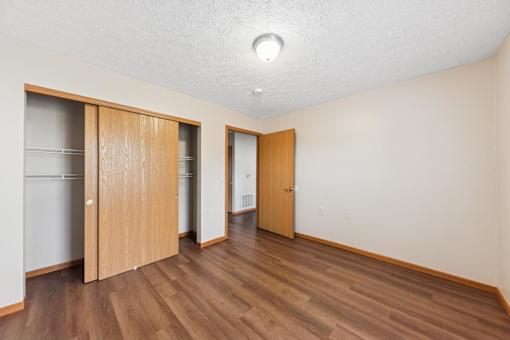 A room with wooden floors and two wooden doors.