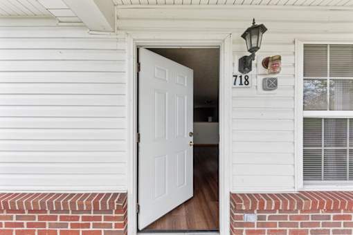 A white door with the number 718 on the side of a house.