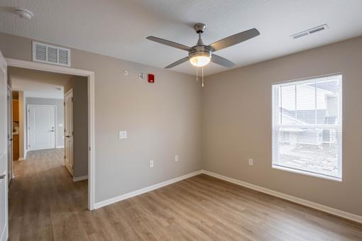 A room with a ceiling fan and a window.