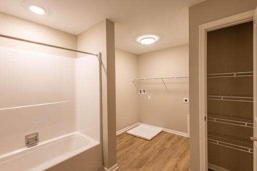 A white bathroom with a walk in shower and a white tub.