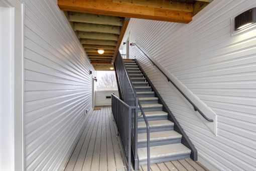 A staircase with a metal railing and wooden steps.
