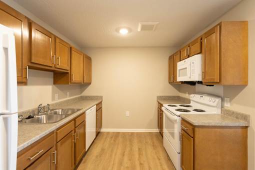 A kitchen with wooden cabinets and a white stove top oven.