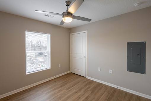 A room with a ceiling fan and a door.