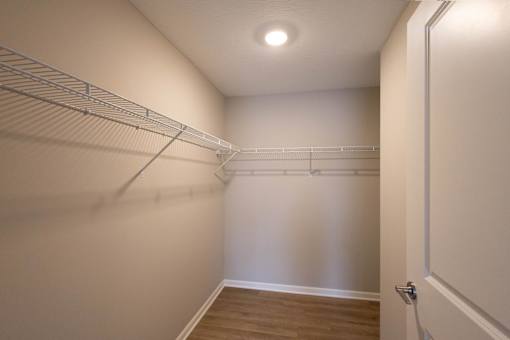 A walk-in closet with a white door and shelves.