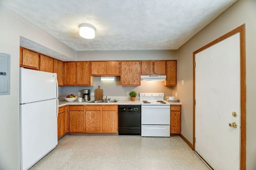 A kitchen with wooden cabinets and a white refrigerator.