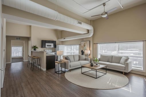 A living room with a white couch, a black coffee table, and a rug on the floor.