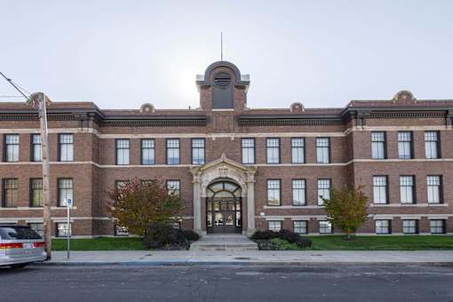 A large red brick building with a central arched entrance.