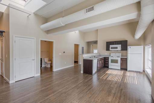 A kitchen with white appliances and wooden floors.