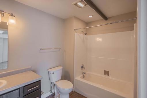 A white toilet sits next to a bathtub in a bathroom.