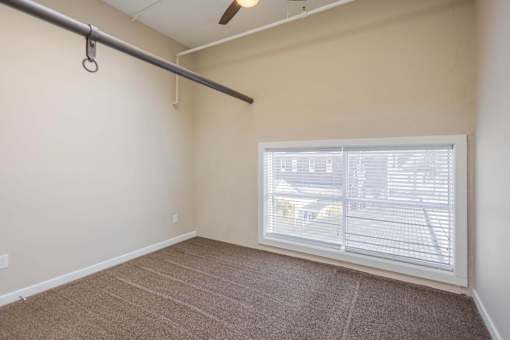 A room with a window covered by white blinds.