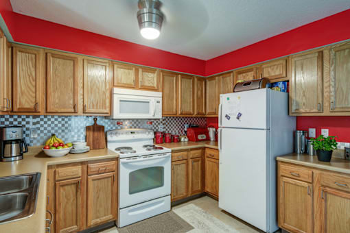 A kitchen with wooden cabinets and a white refrigerator.