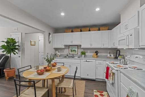 A kitchen with white cabinets and a table set for a meal.