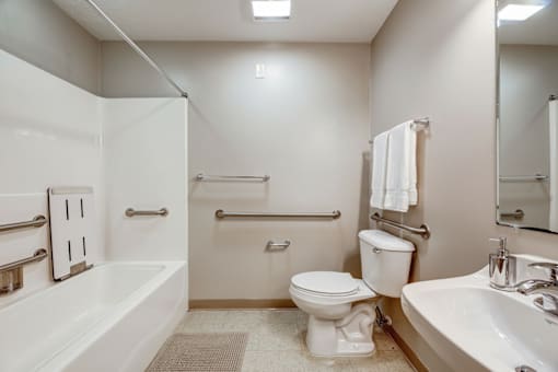 A white bathroom with a toilet, sink, and bathtub.