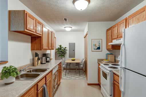 A kitchen with wooden cabinets and white appliances.