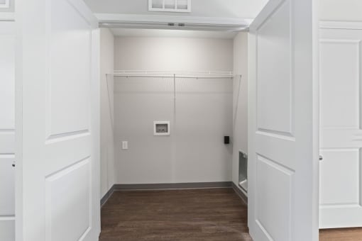 a room with white walls and a wooden floor and a closet