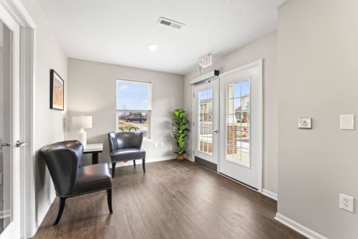a living room with chairs and a door to a patio