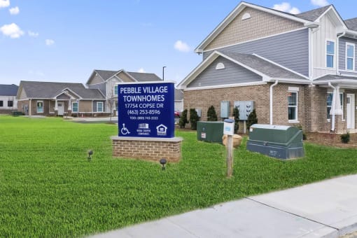 a sign for the peoples village townhomes in front of some houses