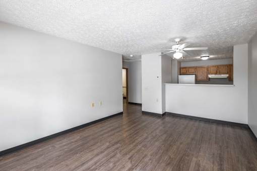 A room with wooden flooring and white walls.