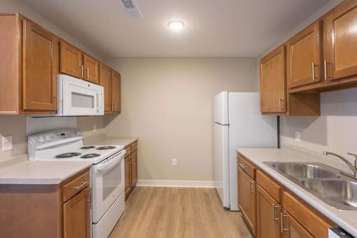 A kitchen with wooden cabinets and white appliances.