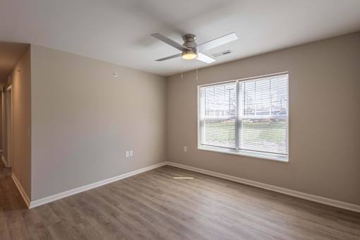 A room with a ceiling fan and a window.