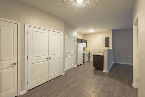 A kitchen area with white cabinets and a refrigerator.