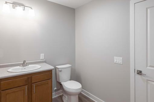 A white toilet sits next to a sink in a bathroom.