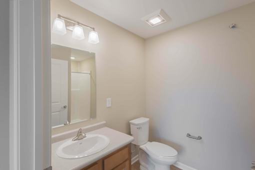 A white toilet sits next to a sink in a bathroom.