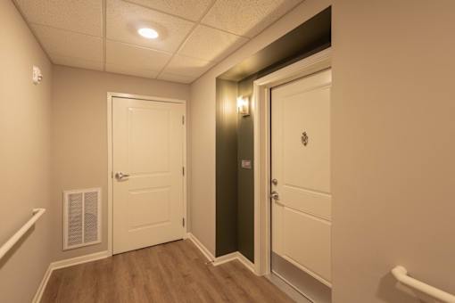 A hallway with a white door and a black door.