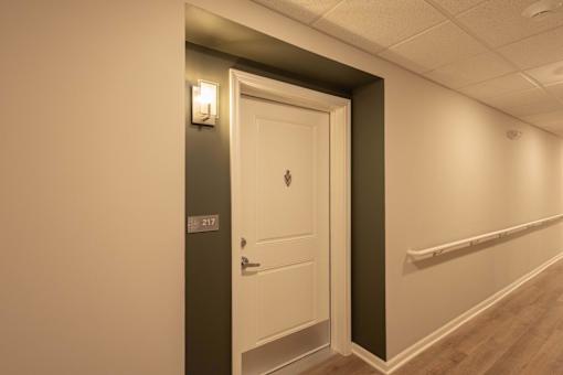A white door with a handle and a number 217 on the wall.