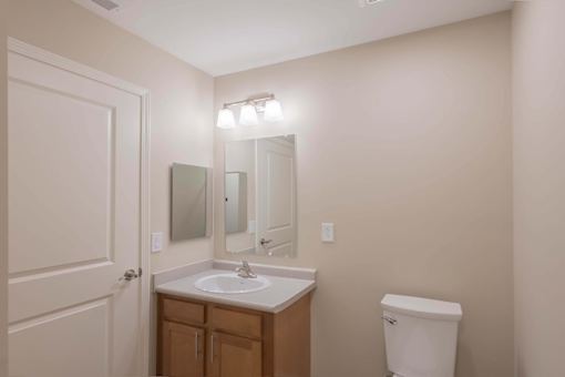 A bathroom with a sink, mirror, and toilet.