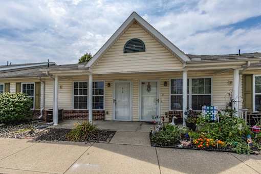 A house with a front yard and a sign in front.