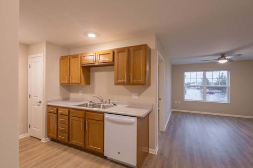 A kitchen with wooden cabinets and a white dishwasher.