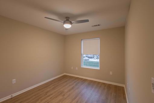 A room with a ceiling fan and a window.