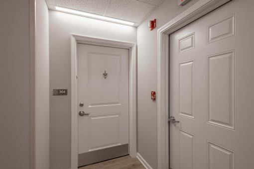 A white door with a number 304 on it is in a hallway.