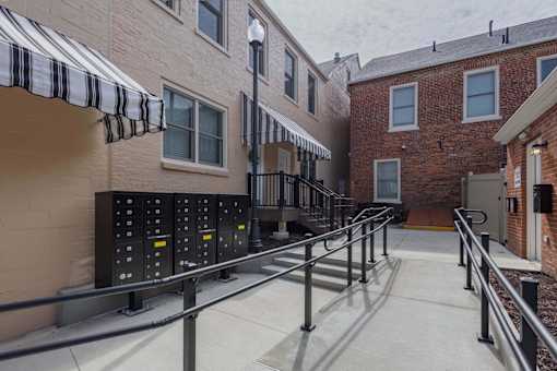 A long metal railing runs down the center of a concrete walkway.